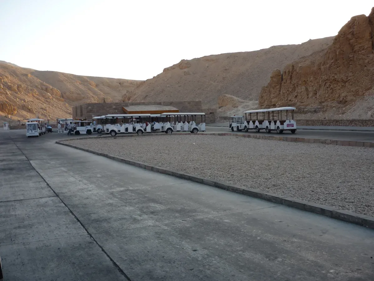 Electric trams lined up at the visitor centre car park in the Valley of the Kings, seen on a Valley of the Kings tour